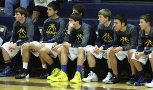 The JV basketball team sits and supports their team mates. | Photo by Michaela Post