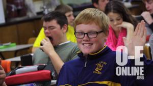 Student Cody Simons smiles and waves at the camera in his second hour Biology class. | Photo by Rebecca McClure