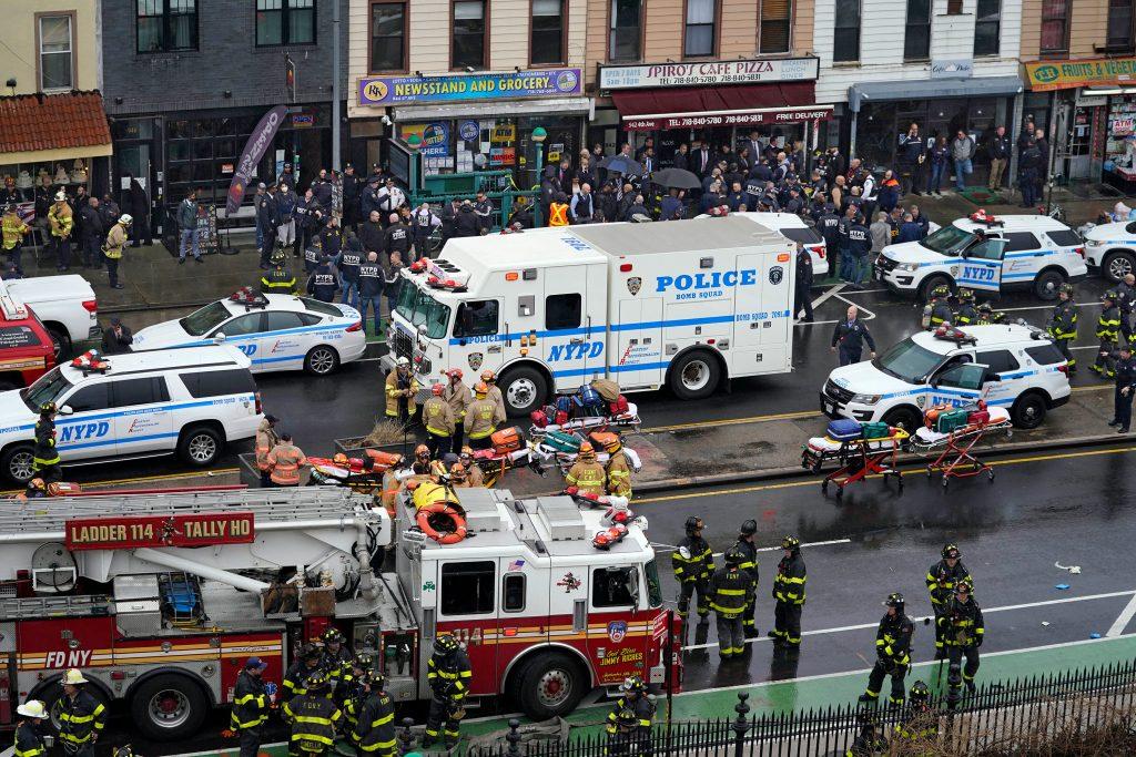 Emergency personnel gather at the entrance to a subway stop in the Brooklyn borough of New York, Tuesday, April 12, 2022.  Multiple people were shot and injured Tuesday at a subway station in New York City during a morning rush hour attack that left wounded commuters bleeding on a train platform. (AP Photo/John Minchillo)